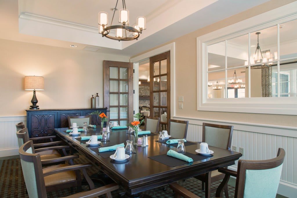 A beautifully decorated dining room with an elegant table setup and chandelier lighting.
