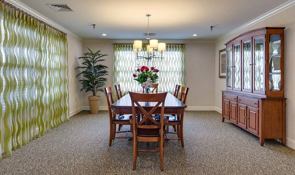 Elegant dining room with a wooden table and chairs, featuring a chandelier and decorative elements.