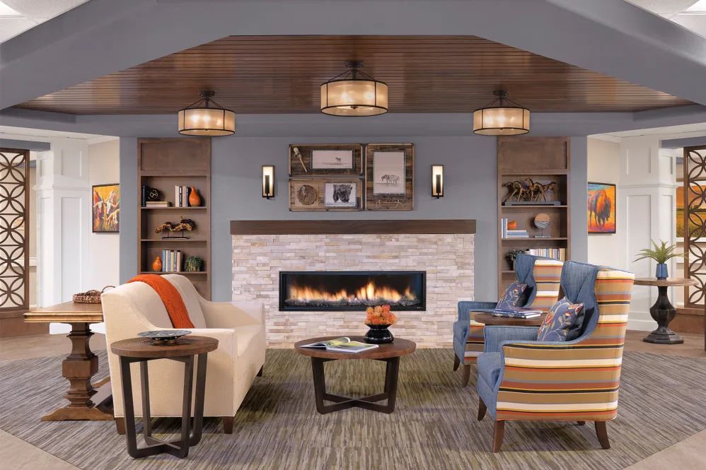 A cozy living room with a modern fireplace, stylish furniture, and elegant lighting.