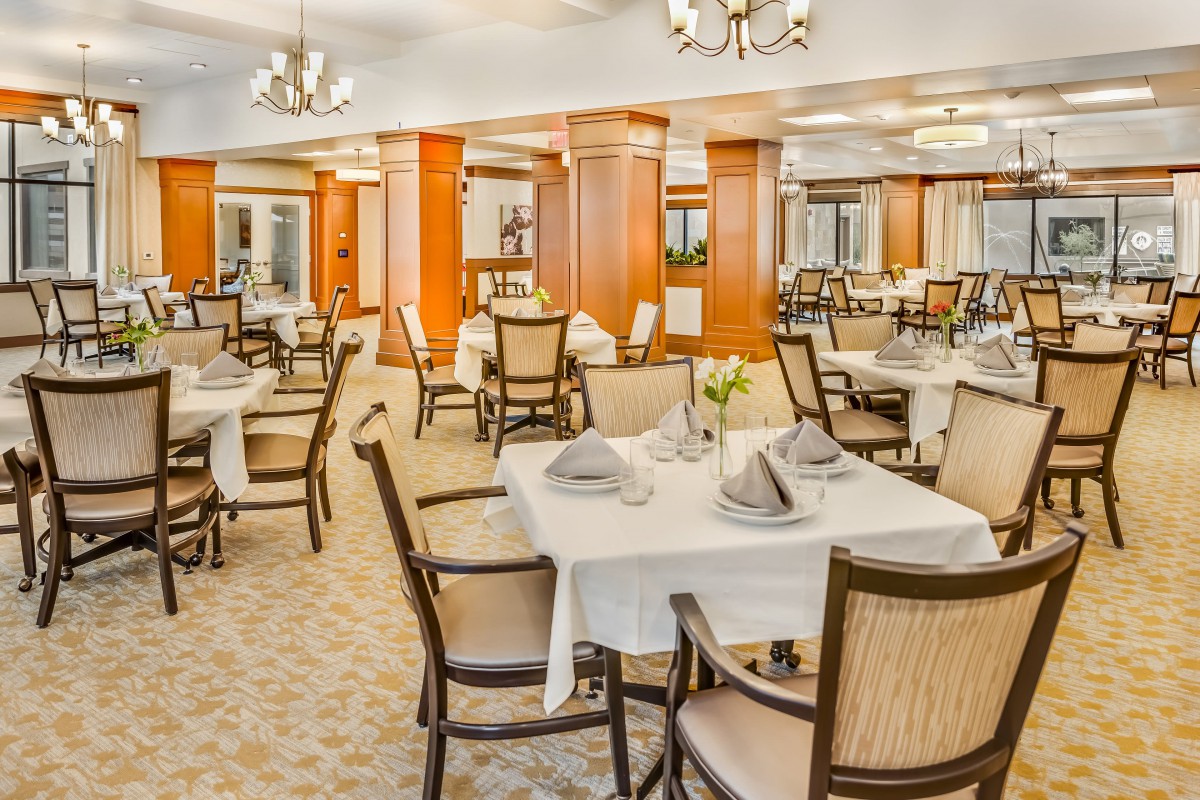 An elegant dining room with neatly arranged tables and chairs.