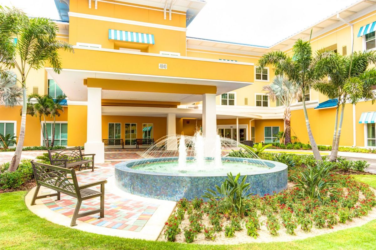 A colorful building featuring a central fountain surrounded by landscaped gardens.