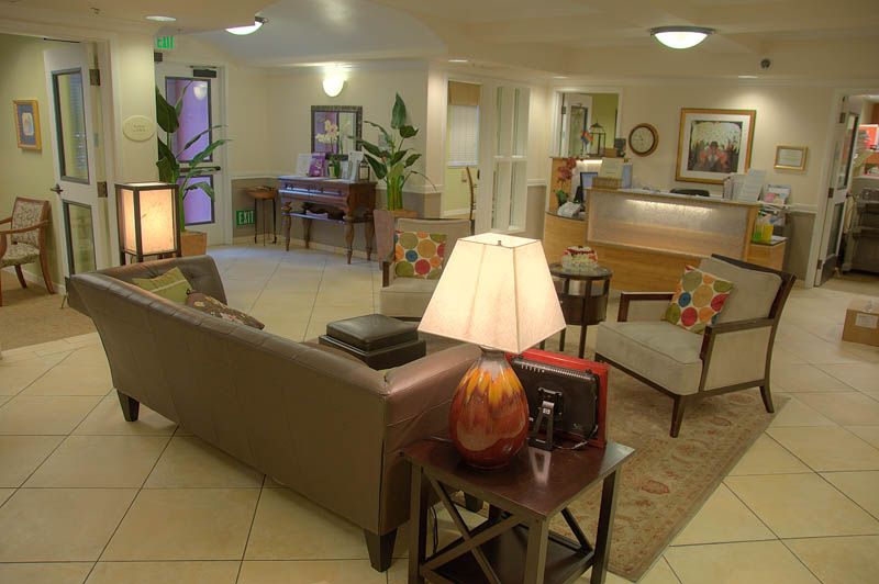 A cozy lobby area with a sofa, lamps, and a reception desk.
