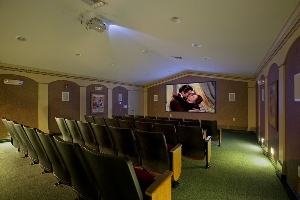 An empty movie theater with a film projected on the screen.