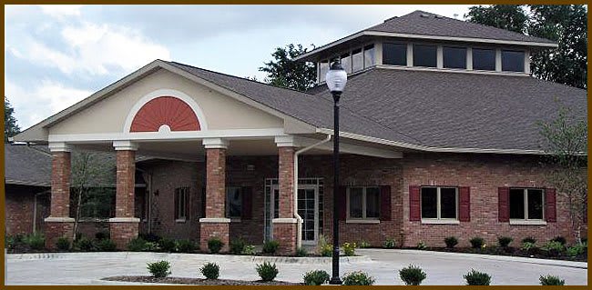 A modern brick building with a gabled roof and a nearby lamp post.