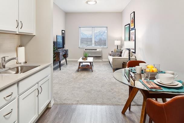 A cozy living room with modern furniture, a television, and a dining area.