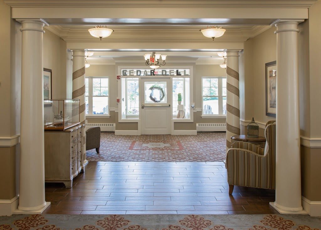 A spacious and elegantly decorated lobby area with comfortable seating, a chandelier, and large windows allowing natural light to fill the space.