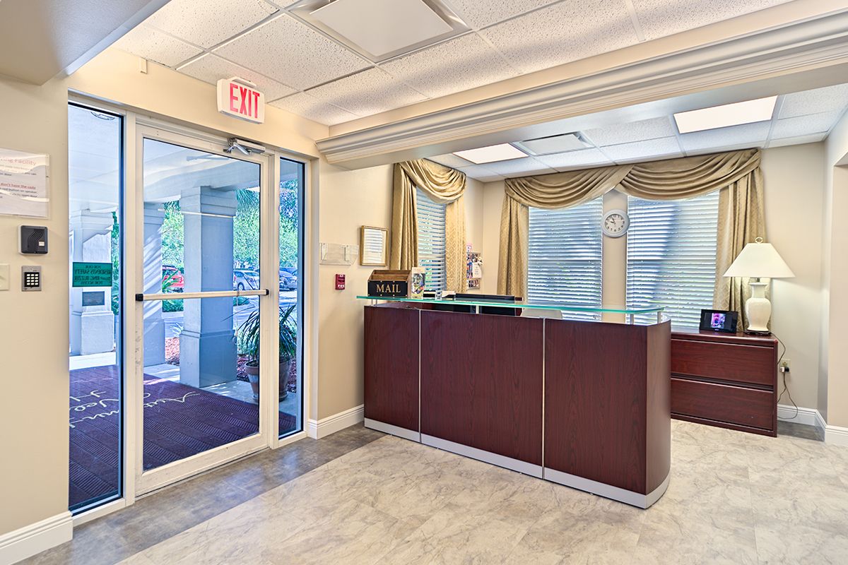 A well-lit office reception area with a desk and glass doors.