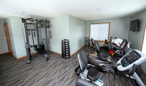 A well-equipped home gym featuring exercise bikes, a strength training machine, and free weights.