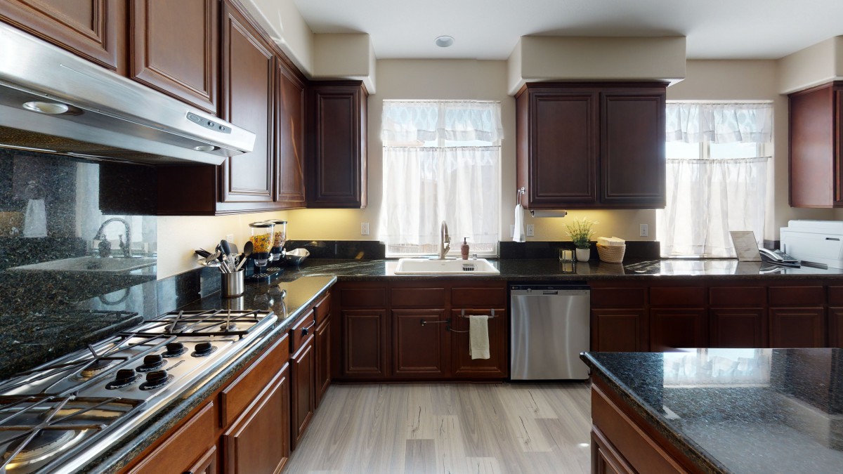 A modern kitchen featuring dark wood cabinets and stainless steel appliances.