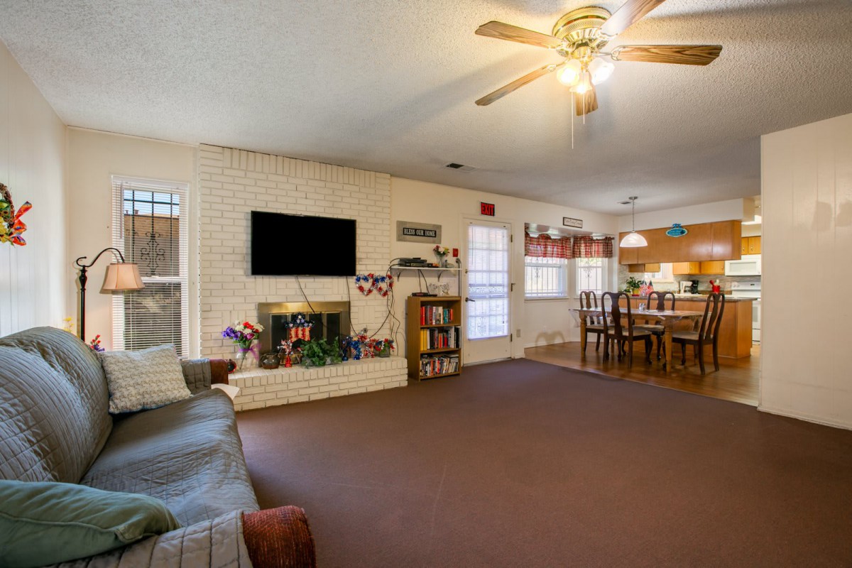 A spacious living room with a fireplace, television, and adjacent dining area.