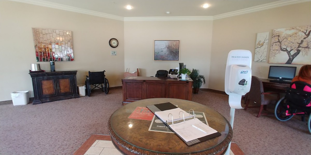 An office interior with a desk, wheelchair, and documents on a table.