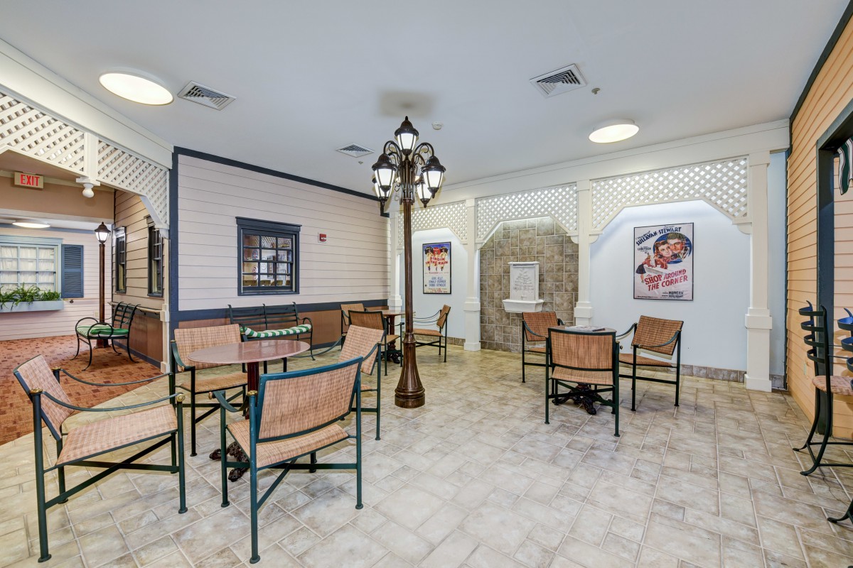 A quaint indoor seating area with tables and chairs, featuring vintage decor and posters on the walls.