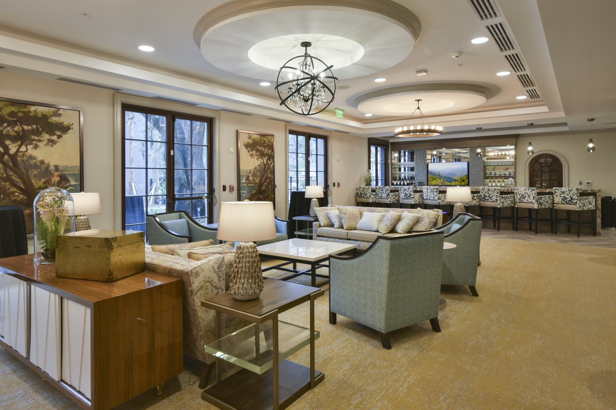 A spacious and elegantly designed living room with comfortable seating and a modern chandelier.