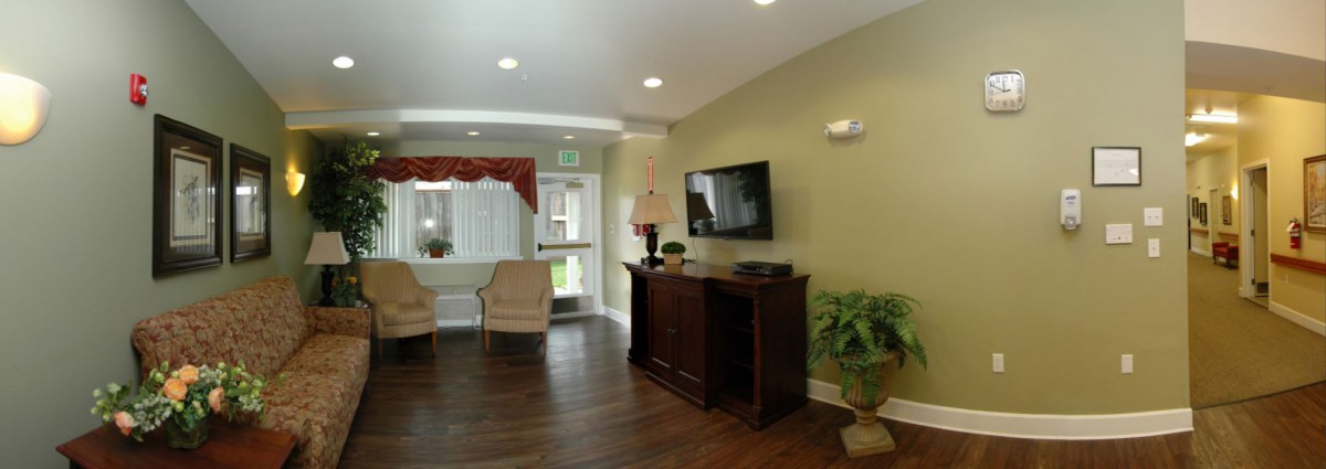 A cozy living room with a TV, armchair, and decorative elements.