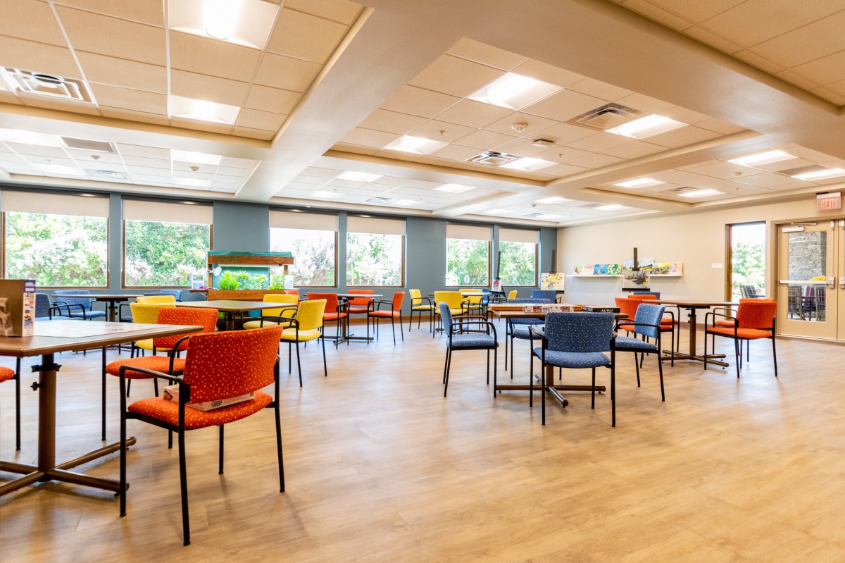 An empty cafeteria with colorful chairs and tables.
