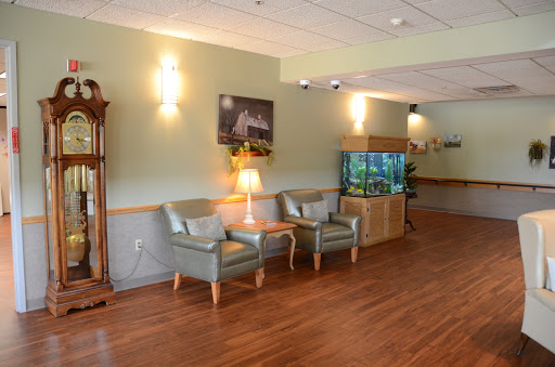 A cozy waiting area featuring comfortable seating, ambient lighting, and an aquarium.