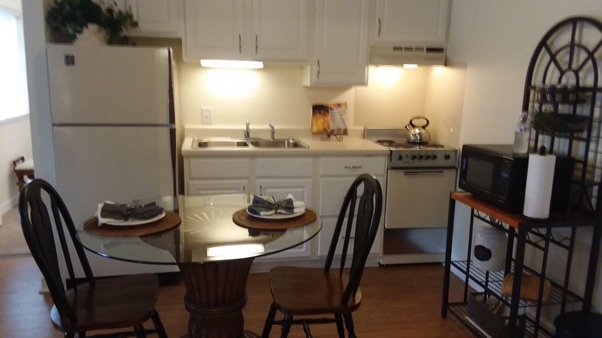 Cozy kitchen with a dining area, featuring a small table and chairs.