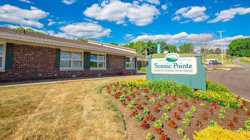 The Scenic Pointe facility surrounded by vibrant flowers and clear blue skies.