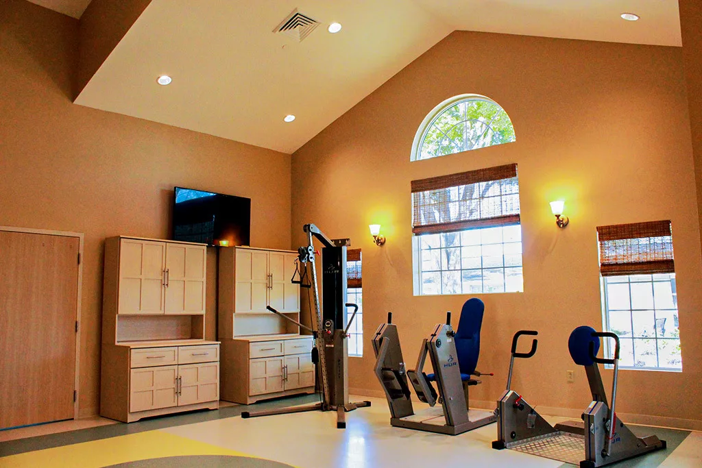 A well-equipped gym with exercise machines and a modern interior design.