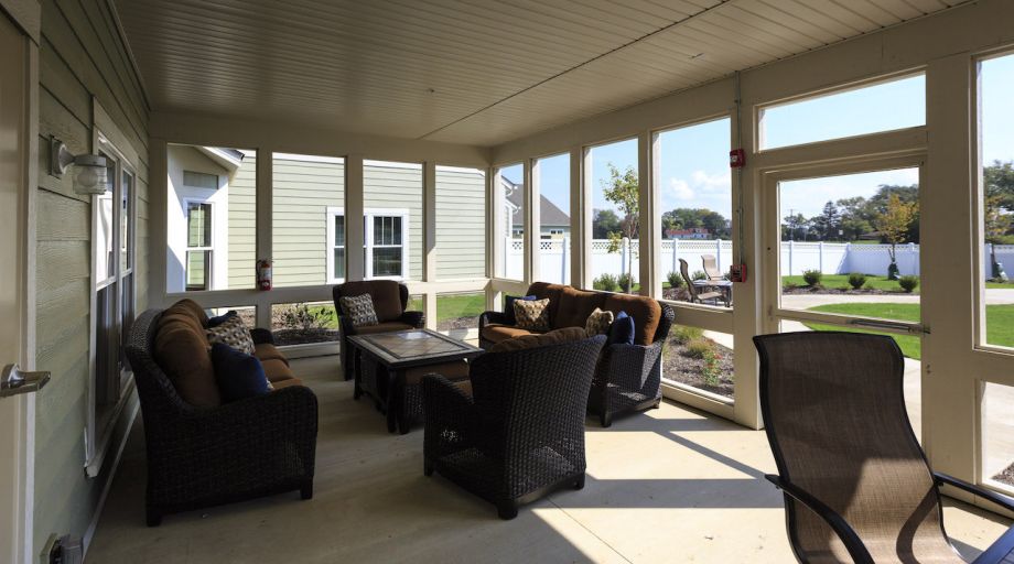 A cozy patio with comfortable seating and large windows allowing plenty of sunlight.