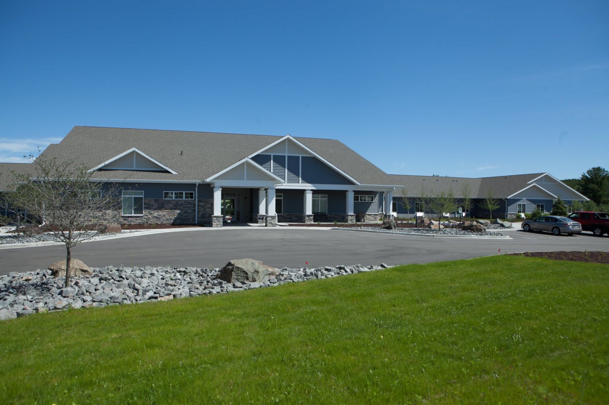 A modern building with a well-maintained lawn under a clear blue sky.