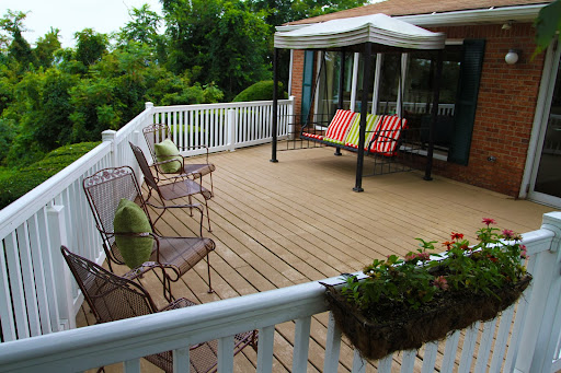 A serene outdoor deck furnished with comfortable seating and surrounded by lush greenery.