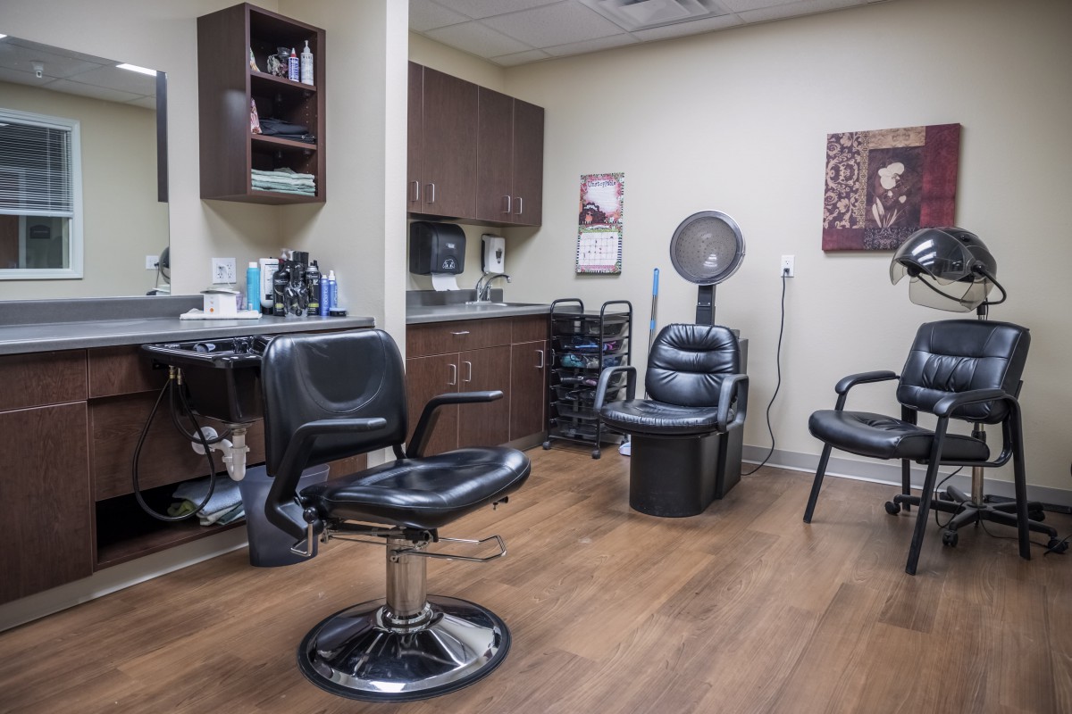 A hair salon interior featuring several chairs and hairdressing equipment.