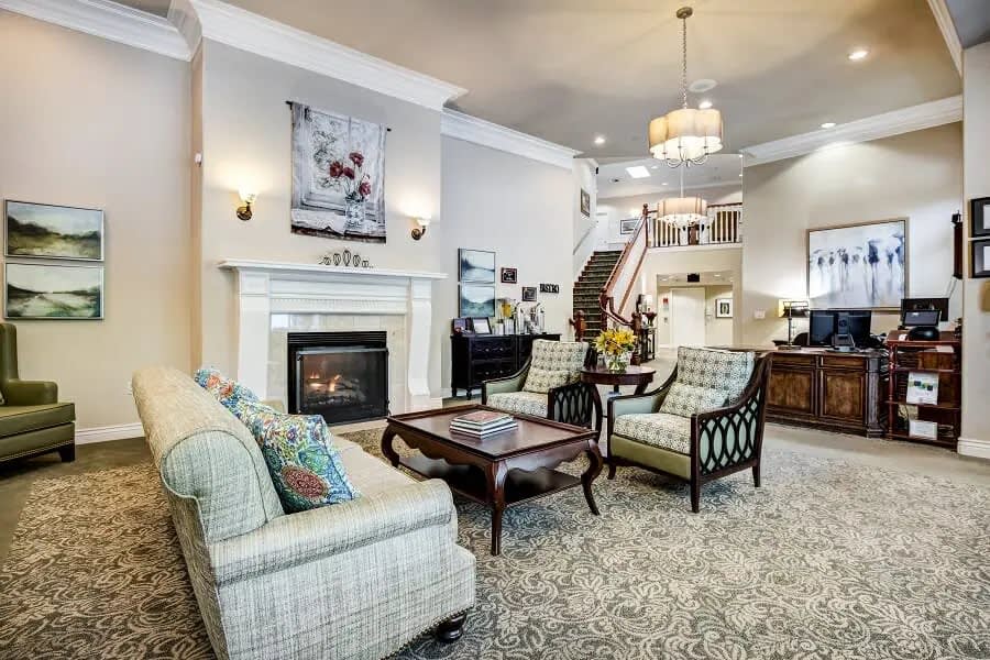 A beautifully designed living room featuring a cozy fireplace, elegant furniture, and a spacious layout with a staircase leading to the upper floor.