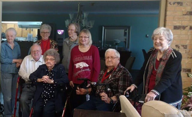 A group of people gathered indoors, smiling for a photo.