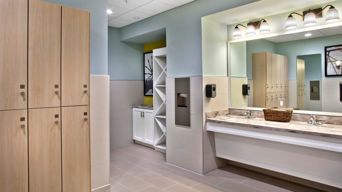 A modern and clean bathroom with a sink and mirror, featuring sleek design elements.
