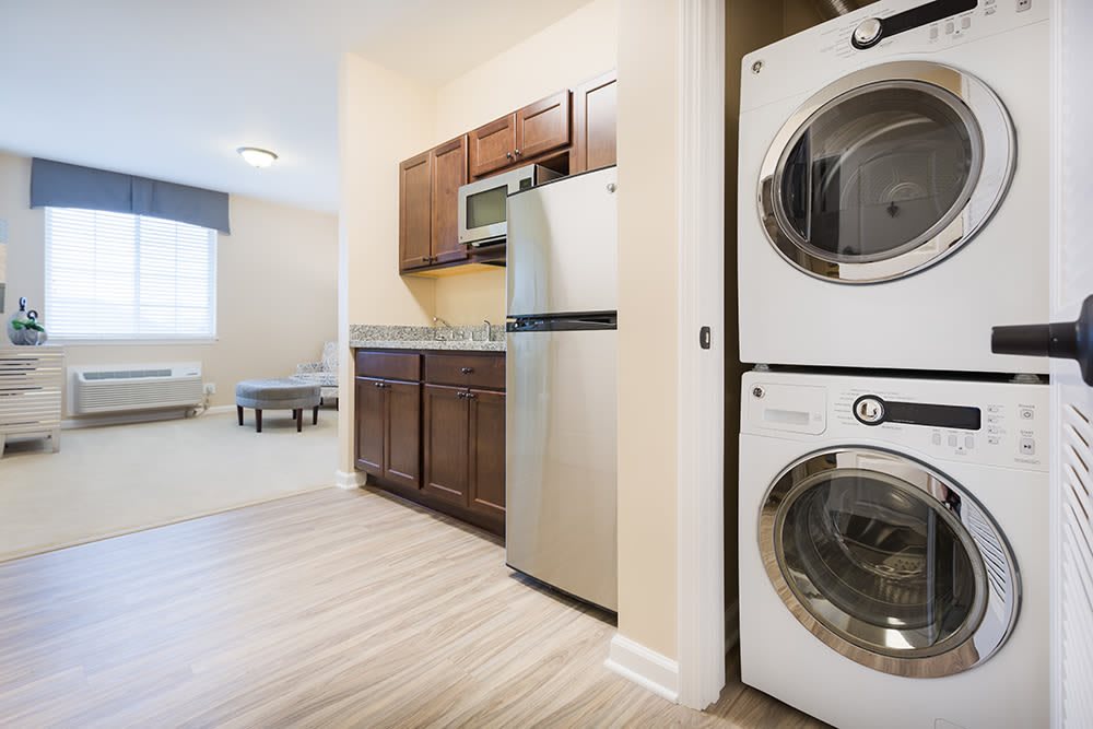 A modern kitchen with a stacked washer and dryer in the corner.