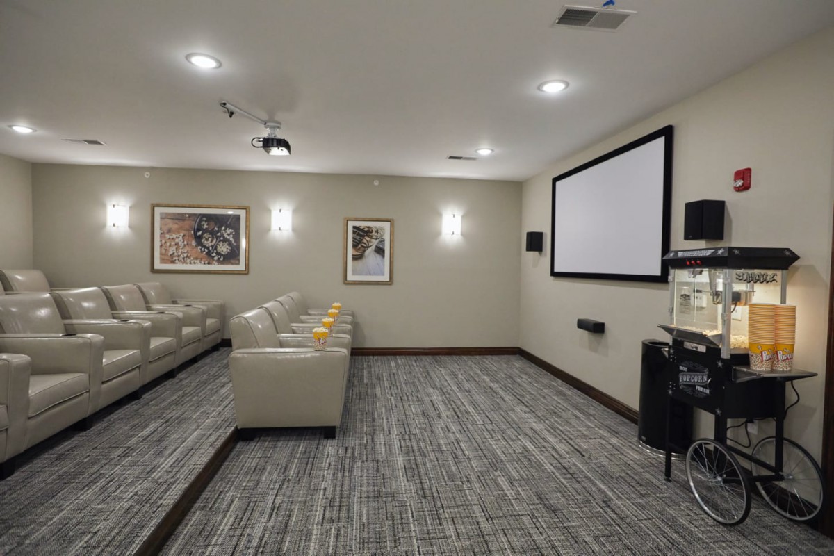 A cozy home theater with comfortable seating and a large projector screen.