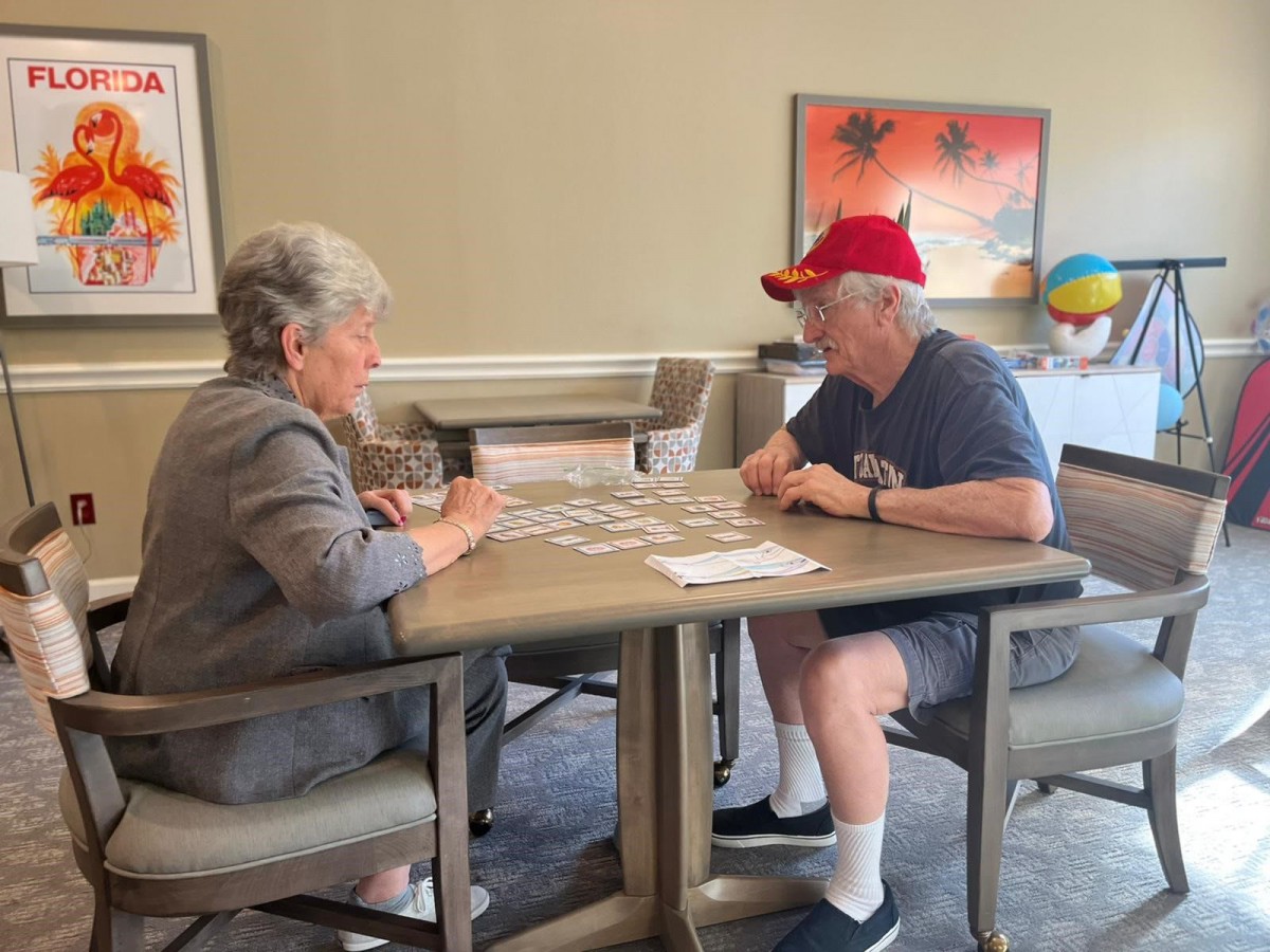 Two elderly individuals enjoying a card game together.