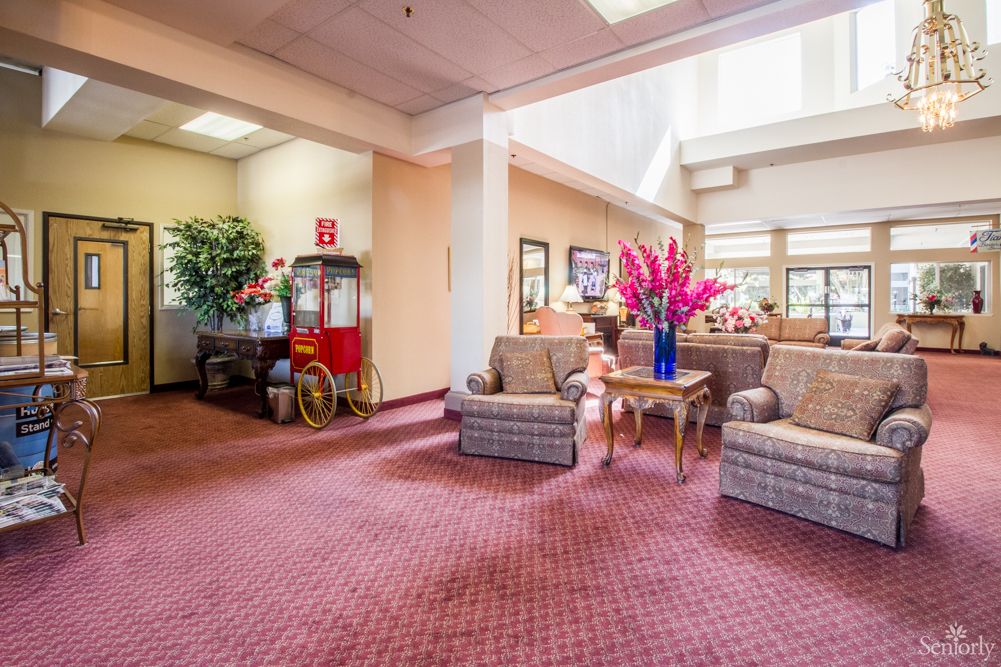 A cozy lobby area featuring comfortable furniture, vibrant floral arrangements, and a nostalgic popcorn machine.