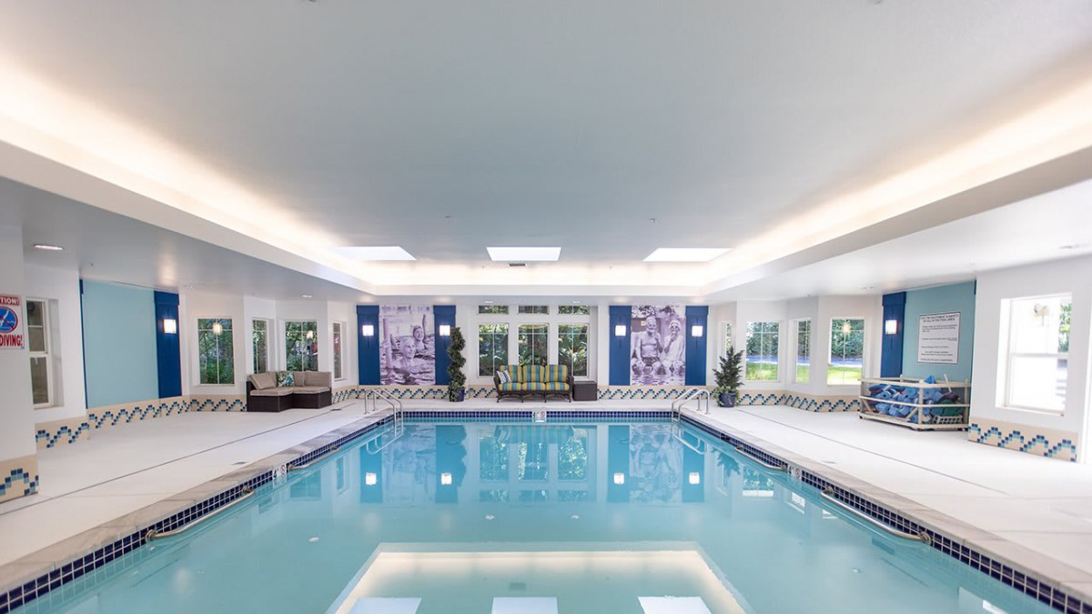 A luxurious indoor swimming pool with elegant decor and ambient lighting.
