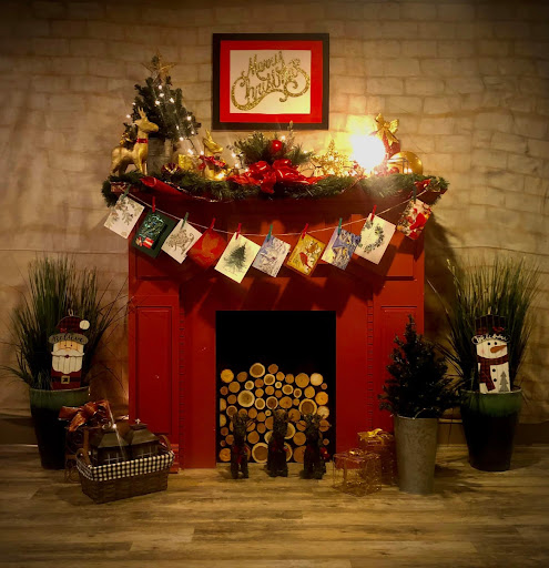 A beautifully decorated red fireplace, adorned with festive garlands and greeting cards, creating a warm holiday ambiance.