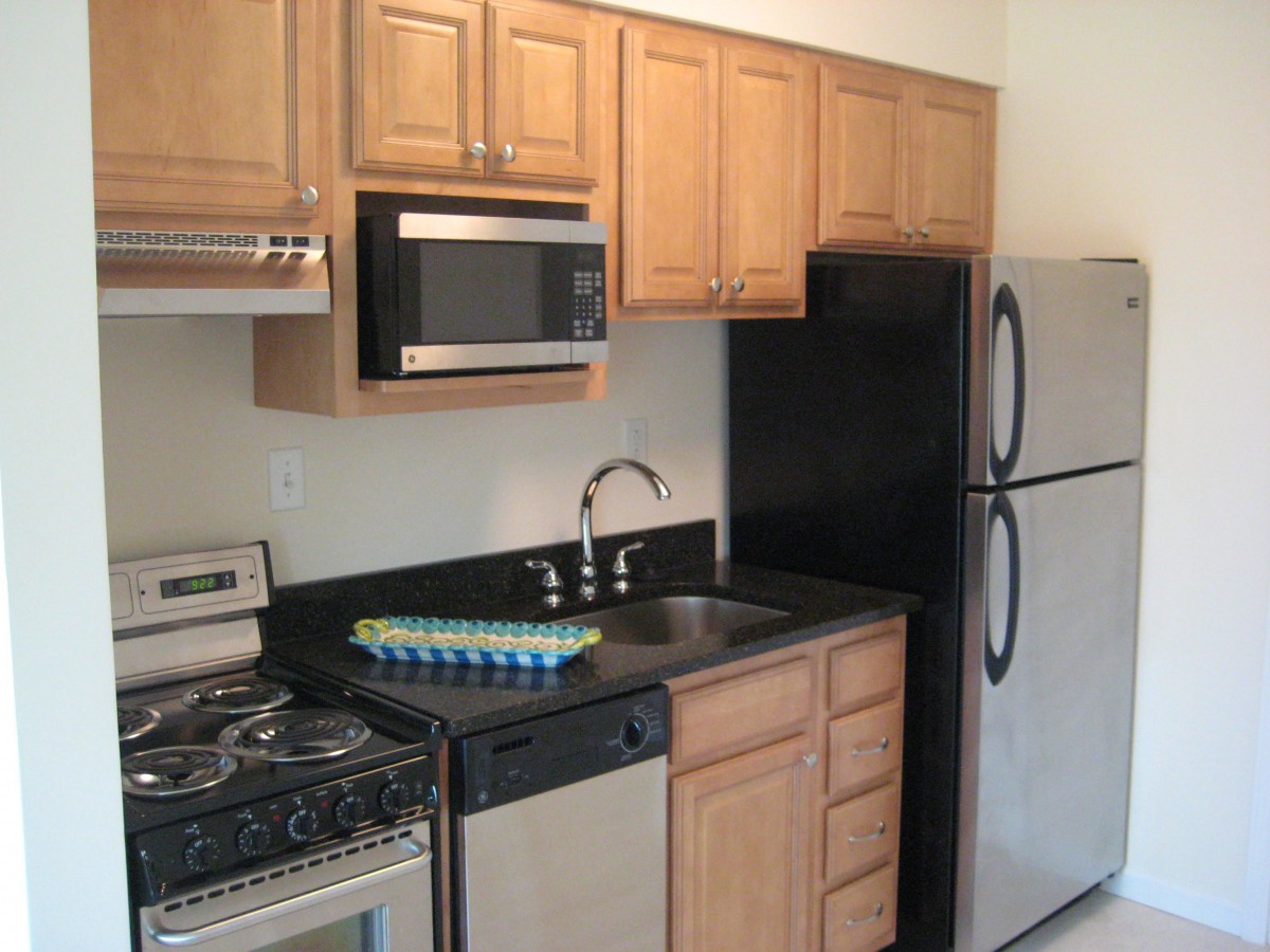 A modern kitchen with stainless steel appliances and wooden cabinets.